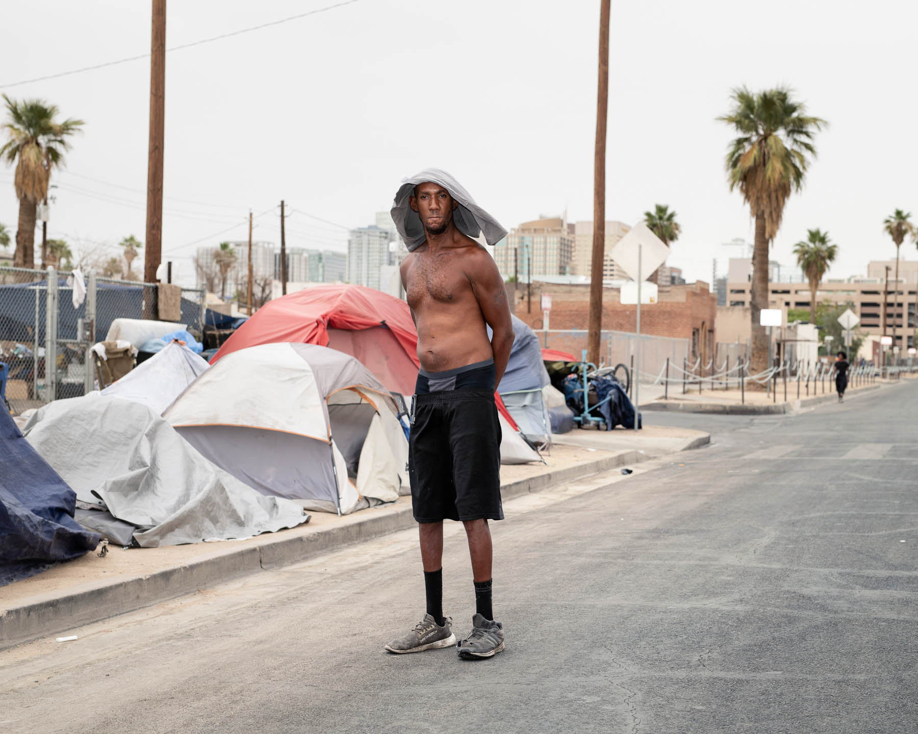 William Calvin “Slim” Sterling stands near his tent on June 14. “It feels like God is holding a magnifying glass to your legs,” said the 39-year-old, who suffered from heatstroke months ago, during what became Phoenix’s hottest June on record. “I can feel the sun cooking my shoulder blades.” For relief, he covers his head with a wet shirt, uses a battery-powered fan and stays as hydrated as possible. “It’s a war zone,” he says. At a nearby shelter with shade, “it’s like peace.”